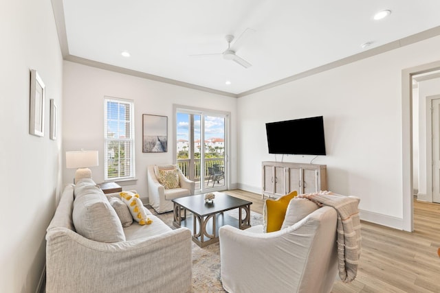 living room featuring light hardwood / wood-style floors, ceiling fan, and crown molding