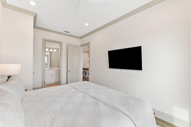 bedroom featuring connected bathroom, hardwood / wood-style flooring, and ornamental molding