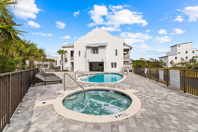 view of swimming pool featuring a hot tub