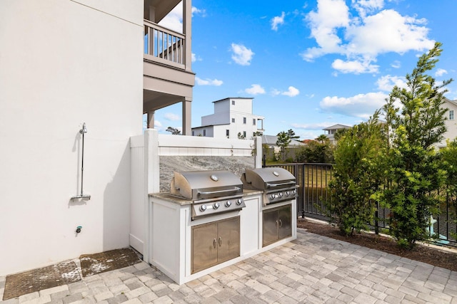 view of patio featuring area for grilling and a balcony