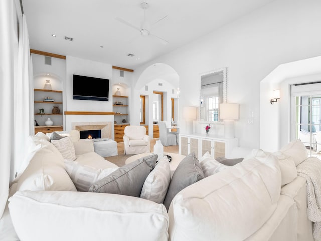 living room featuring built in features and ceiling fan