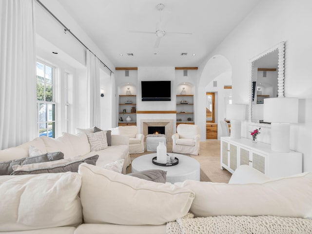 living room featuring built in features and ceiling fan