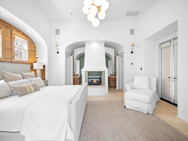 carpeted bedroom with an inviting chandelier and a multi sided fireplace