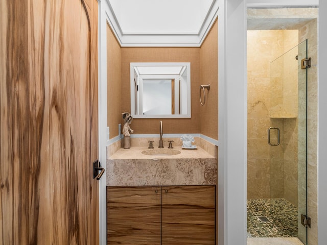 bathroom featuring a shower with door and vanity