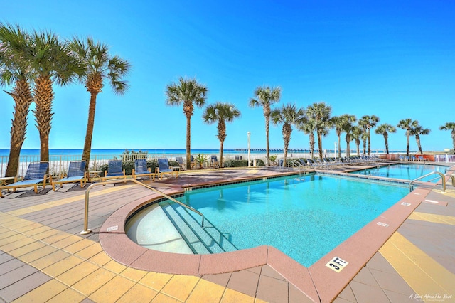 view of pool featuring a water view and a patio area