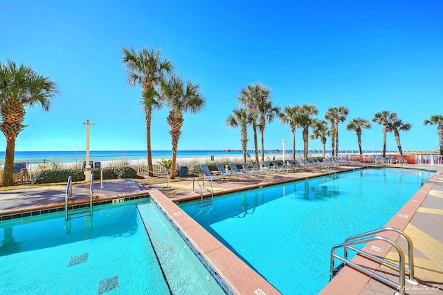 view of swimming pool featuring a water view and a patio