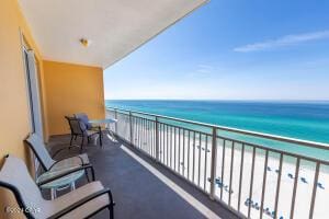 balcony with a water view and a view of the beach