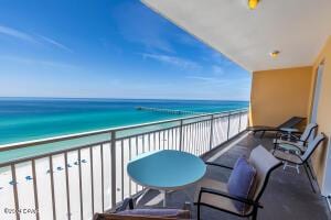 balcony featuring a water view and a view of the beach