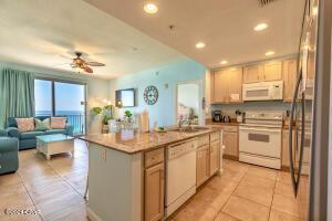 kitchen featuring a kitchen island, white appliances, sink, and light tile patterned floors