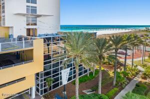 view of building exterior with a beach view and a water view