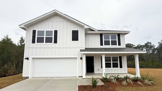 view of front of house featuring a porch, a garage, and a front yard