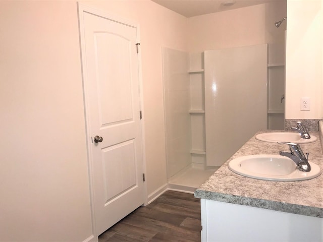 bathroom featuring walk in shower, vanity, and hardwood / wood-style flooring