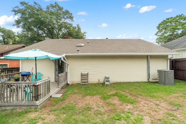 back of house with central AC unit, a deck, and a yard