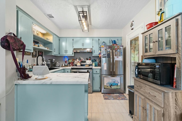 kitchen with light tile patterned flooring, kitchen peninsula, a textured ceiling, and appliances with stainless steel finishes