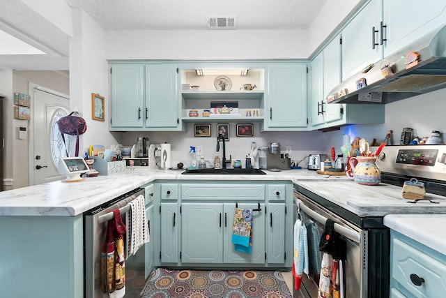 kitchen featuring a textured ceiling, kitchen peninsula, sink, and appliances with stainless steel finishes