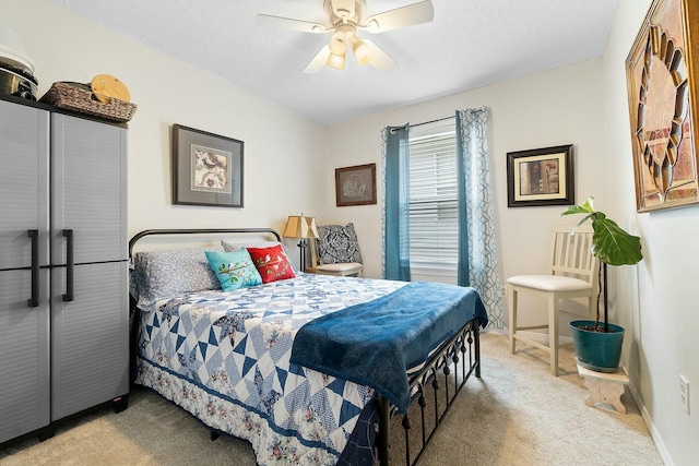 carpeted bedroom with ceiling fan and a textured ceiling