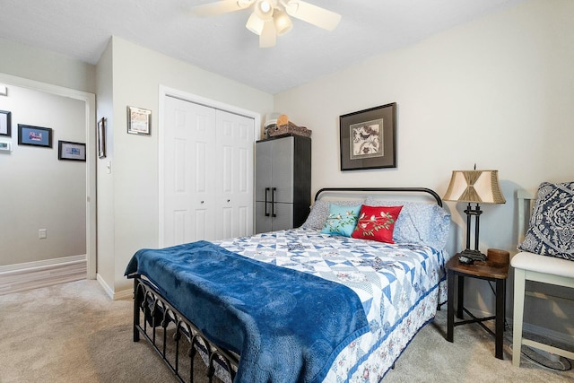 bedroom with ceiling fan, light carpet, and a closet