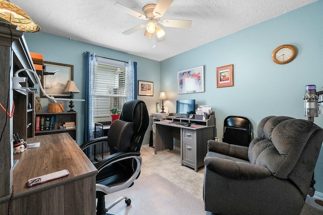 carpeted home office featuring ceiling fan and a textured ceiling