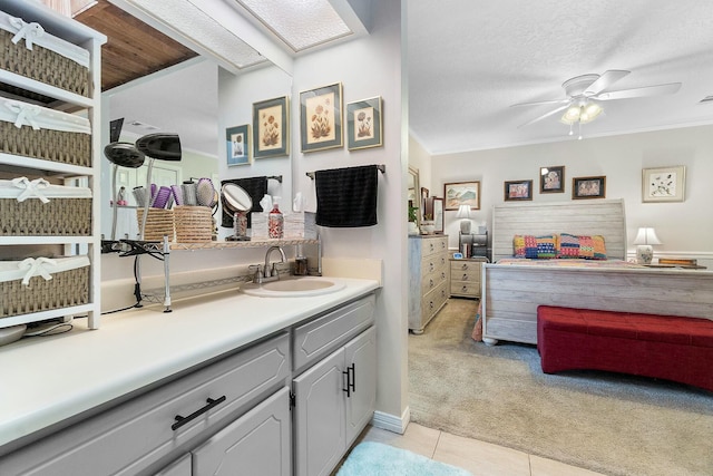 bathroom with ceiling fan, tile patterned floors, crown molding, a textured ceiling, and vanity