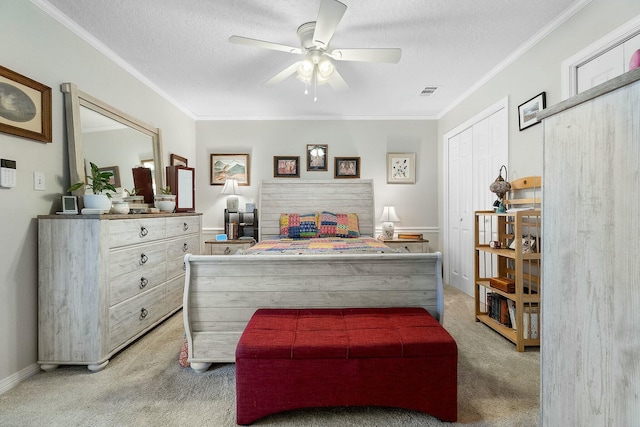 carpeted bedroom featuring ceiling fan, ornamental molding, a textured ceiling, and a closet