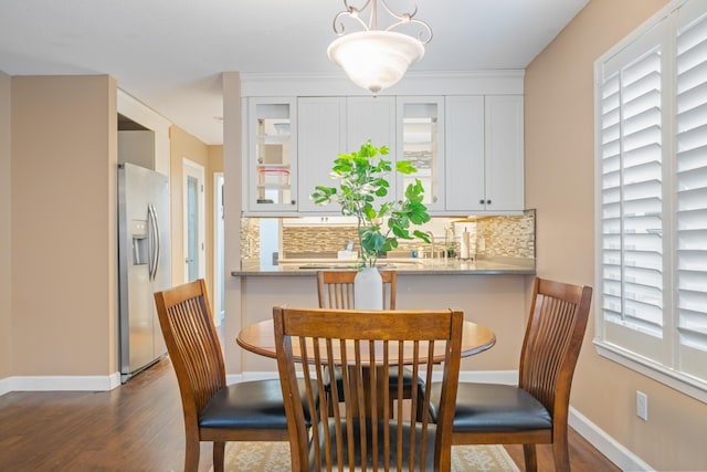 dining space featuring crown molding and dark wood-type flooring