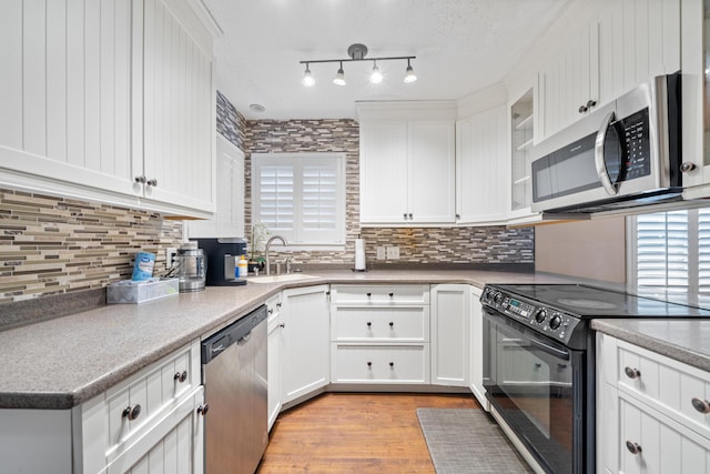 kitchen featuring a healthy amount of sunlight, white cabinetry, sink, and stainless steel appliances