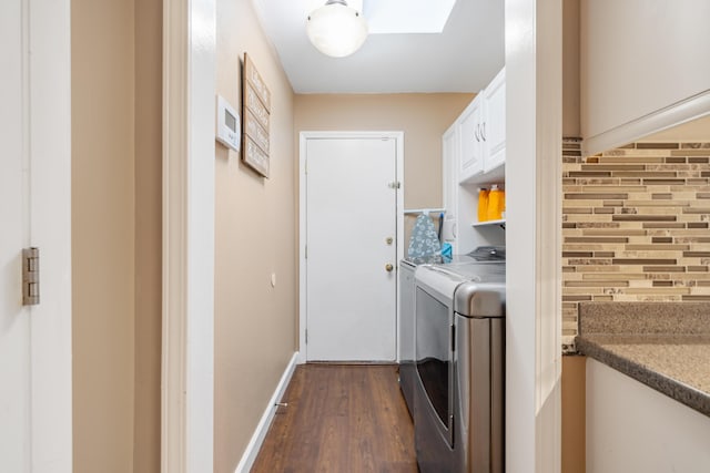 clothes washing area with a skylight, cabinets, washer and dryer, and dark hardwood / wood-style floors