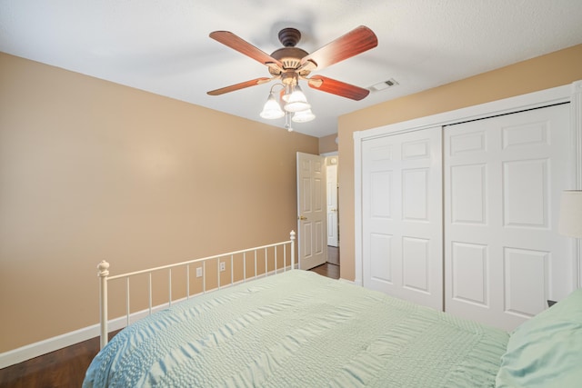 bedroom with ceiling fan, dark hardwood / wood-style floors, and a closet