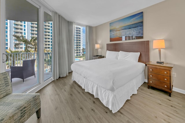 bedroom featuring light wood-type flooring, access to outside, and multiple windows