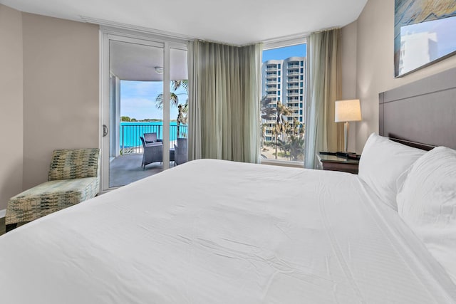 bedroom featuring expansive windows, access to exterior, and multiple windows