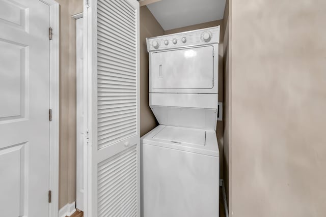 clothes washing area with stacked washer / dryer