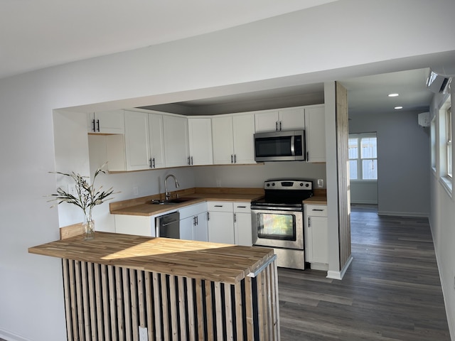 kitchen with dark hardwood / wood-style floors, sink, white cabinetry, and stainless steel appliances