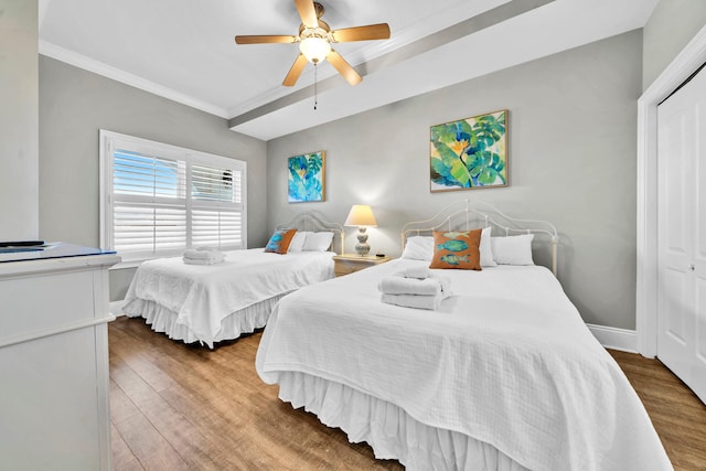 bedroom featuring ceiling fan, a closet, hardwood / wood-style floors, and ornamental molding