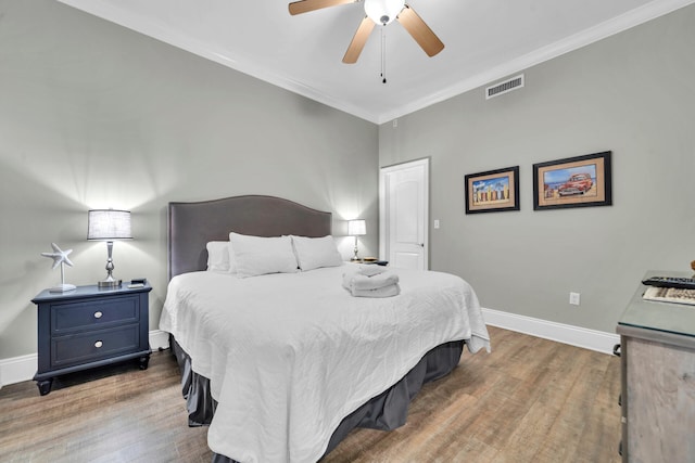 bedroom featuring hardwood / wood-style flooring, ceiling fan, and ornamental molding