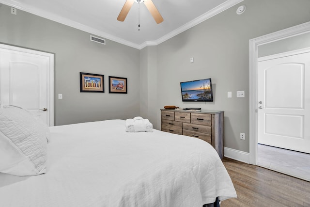 bedroom featuring ceiling fan, wood-type flooring, and ornamental molding