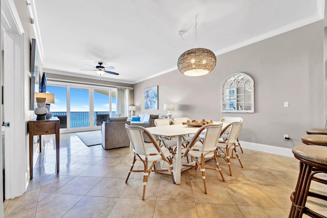 dining room with ceiling fan, light tile patterned flooring, a water view, and crown molding