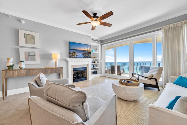 living room featuring light tile patterned floors, built in features, ceiling fan, and crown molding