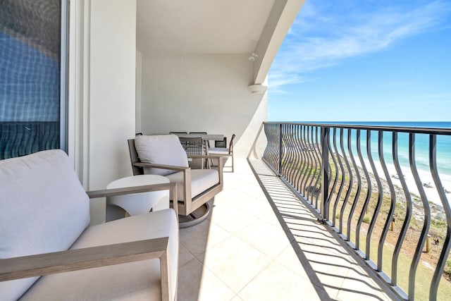 balcony featuring a water view and a beach view