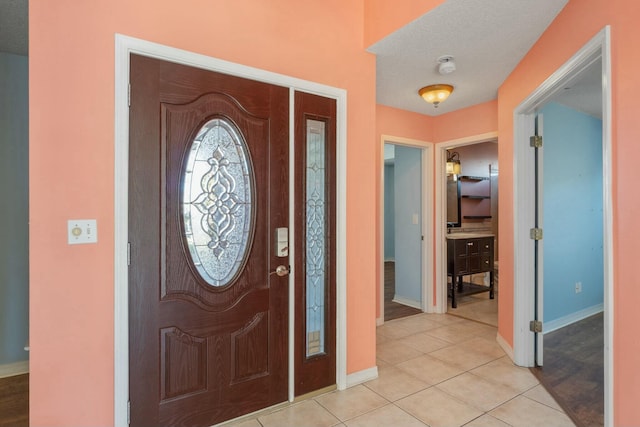 foyer featuring light tile patterned floors and a textured ceiling