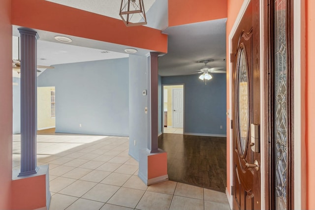 foyer entrance featuring ornate columns, ceiling fan, and light tile patterned flooring