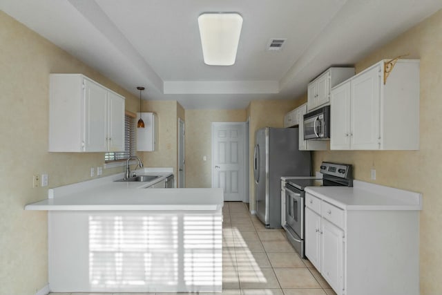 kitchen featuring white cabinets, kitchen peninsula, and appliances with stainless steel finishes