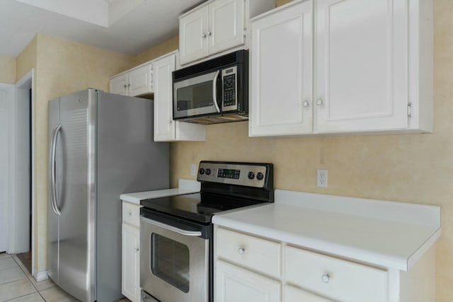 kitchen with white cabinets, light tile patterned floors, and appliances with stainless steel finishes