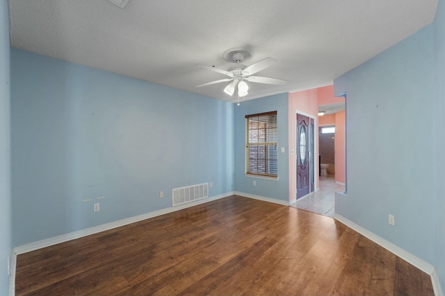 empty room with a textured ceiling, light hardwood / wood-style floors, and ceiling fan