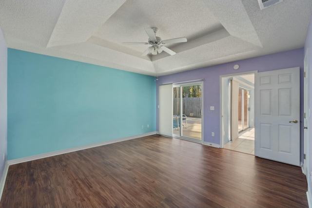 spare room featuring a raised ceiling, ceiling fan, hardwood / wood-style floors, and a textured ceiling