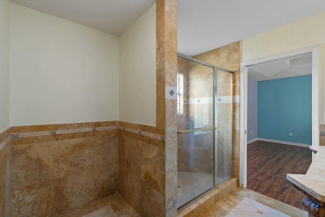 bathroom featuring a textured ceiling, tile patterned floors, and a shower with shower door