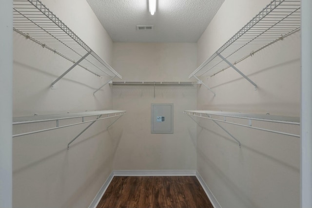 walk in closet with dark hardwood / wood-style flooring and electric panel