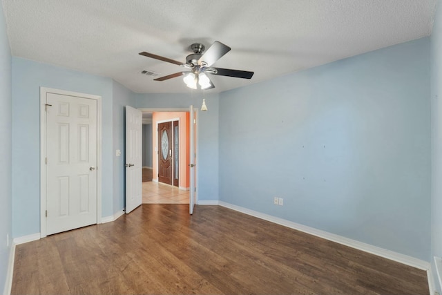 spare room featuring hardwood / wood-style floors, a textured ceiling, and ceiling fan