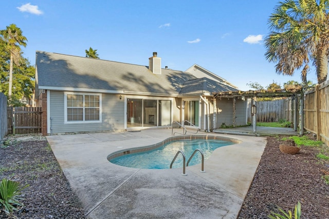 back of property with a patio area and a fenced in pool