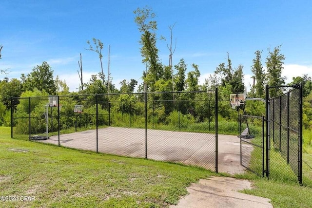 view of basketball court with a yard