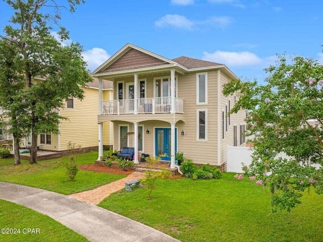 view of front of home with a balcony, a porch, and a front lawn